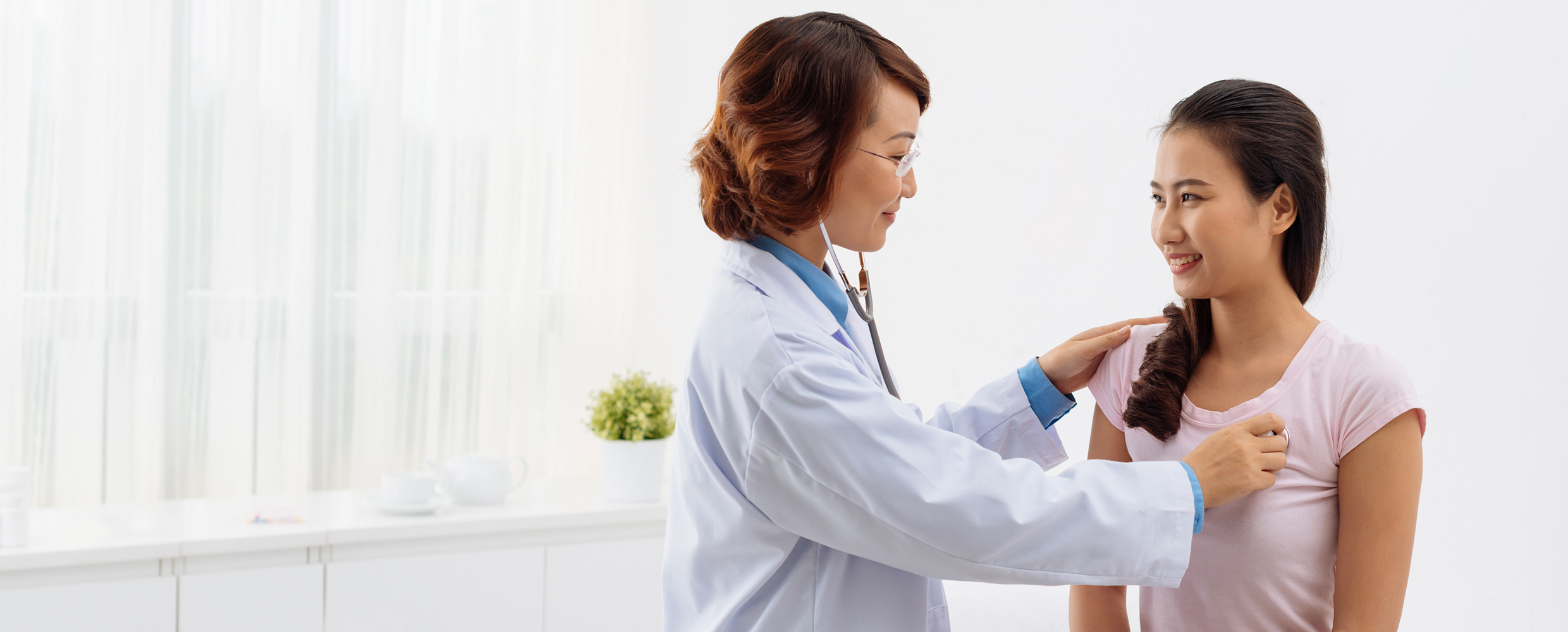 A female Keck Medicine of USC cardiologist examines a young woman for arrhythmias with a stethoscope
