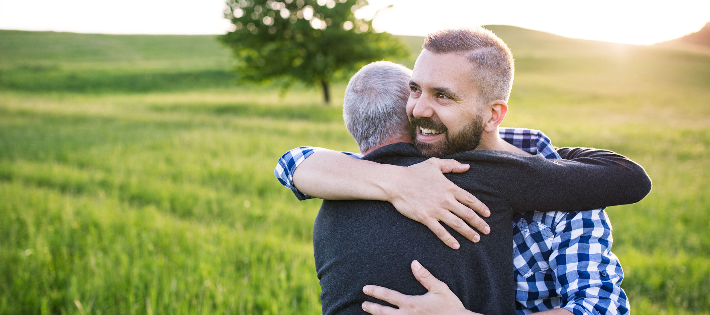 Two men hugging in an open field