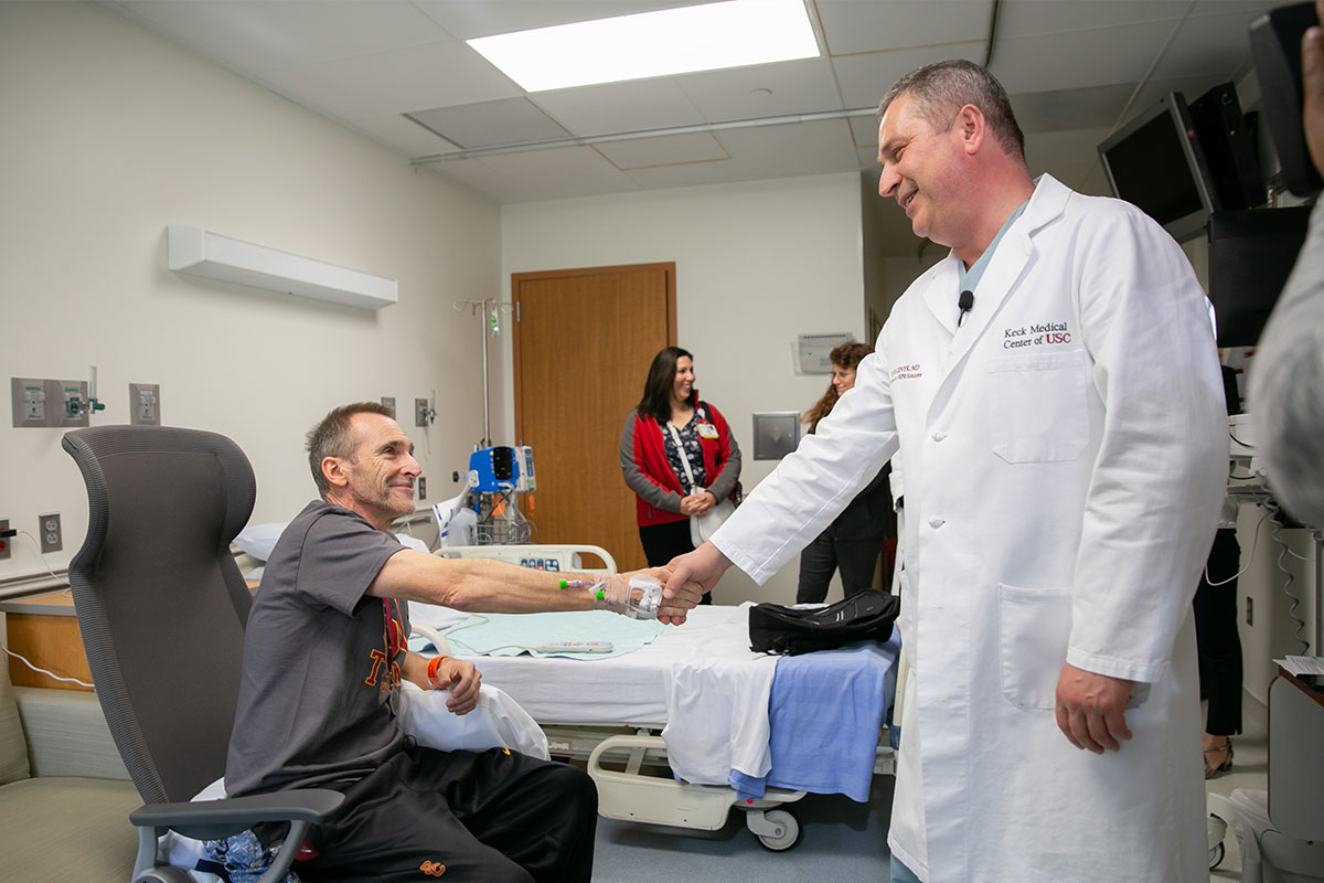 Doctor Yuri Genyk, division chief of hepatobiliary, pancreatic and abdominal organ transplant surgery at Keck Medicine of USC, shakes hand with a patient.