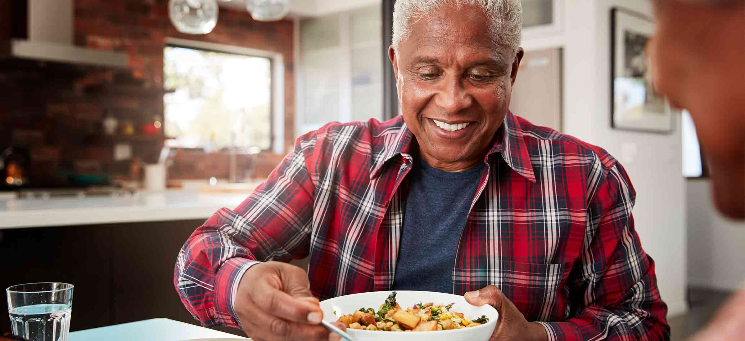 Senior couple enjoying meal around table at home.