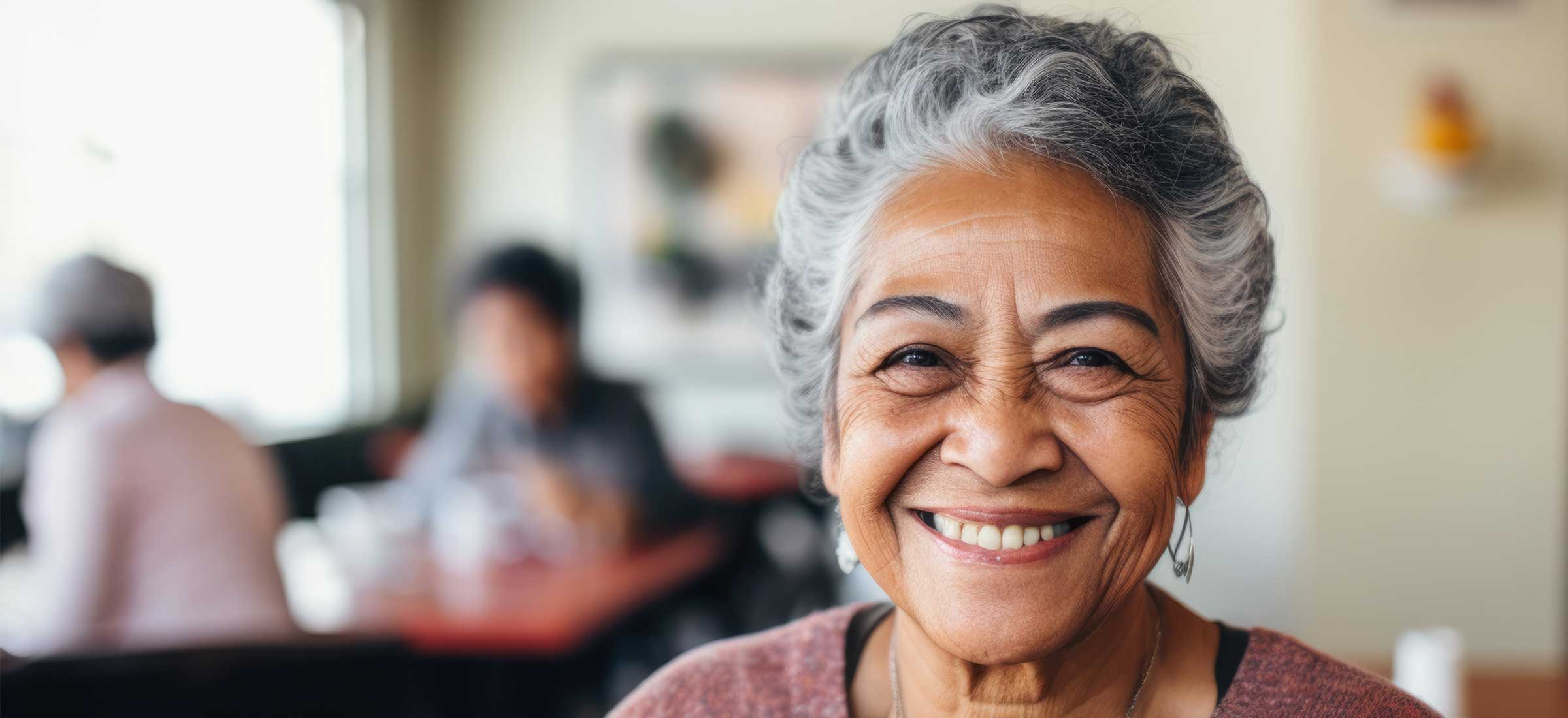 A smiling portrait of a happy senior latina woman in a nursing home.