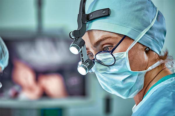 A surgeon stands in an operating room.