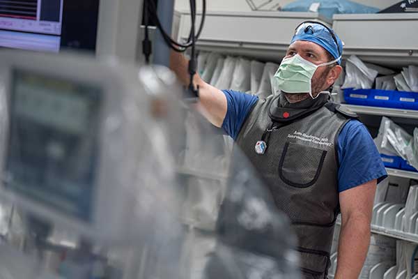 Dr. Antreas Hindoyan, MD, a cardiology and heart valve repair specialist at Keck Medicine of USC, examines information on a monitor in a hospital room