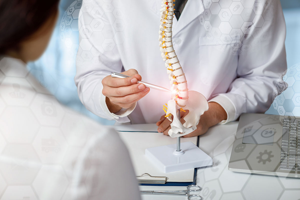 Doctor advising patient about problem areas of the spine on a blurred background.
