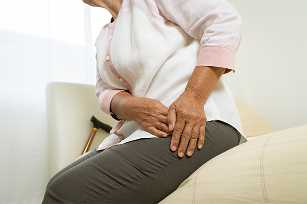 A patient holds her hip.