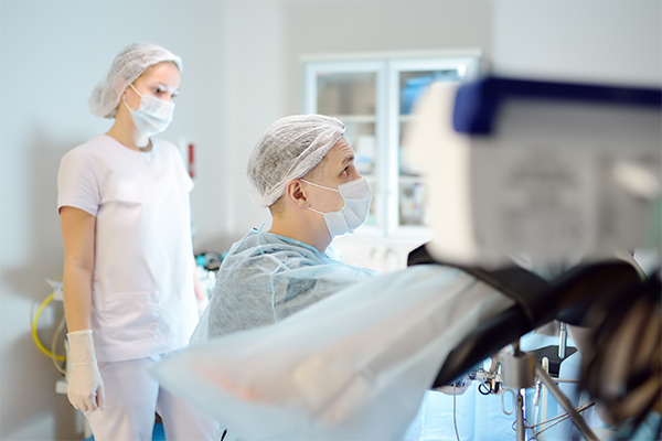 Two surgeons look at a monitor in an operating room.