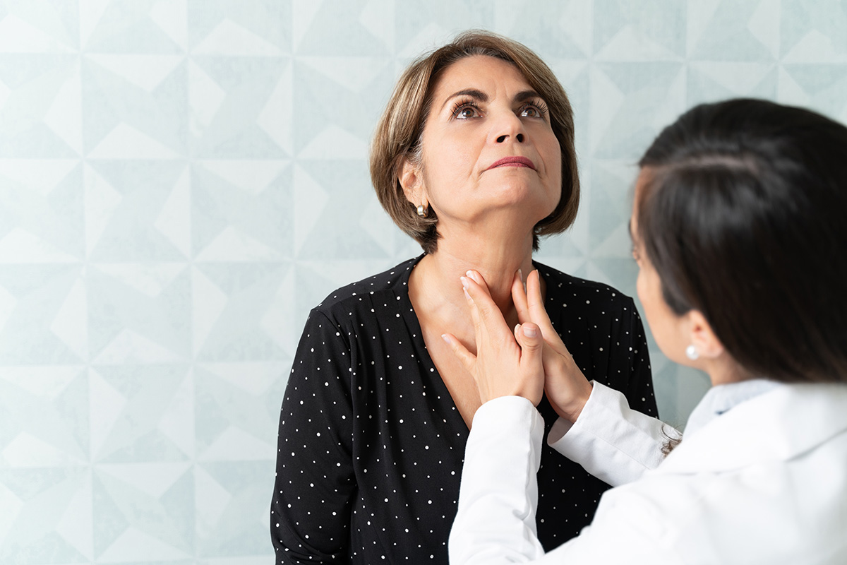 Doctor examines a female patients neck and throat