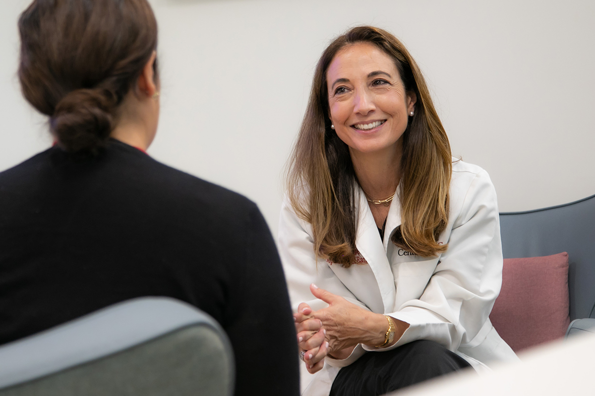 A patient in a black shirt discusses her MRI results with a Keck Medicine of USC radiology expert who is smiling