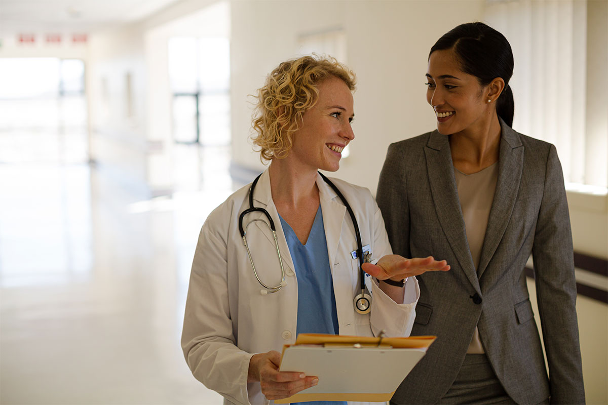 A doctor leads a woman in conversation during an executive health examination.