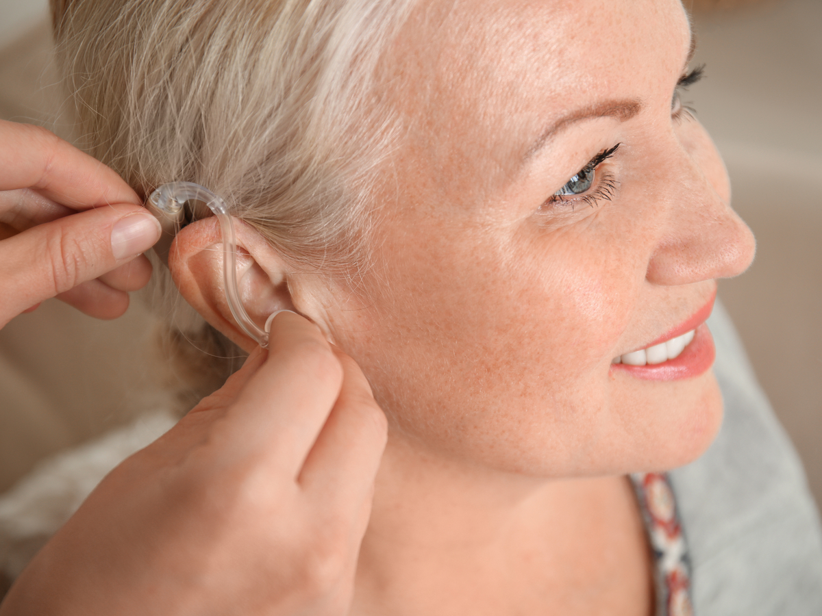 A woman is fitted for a hearing aid