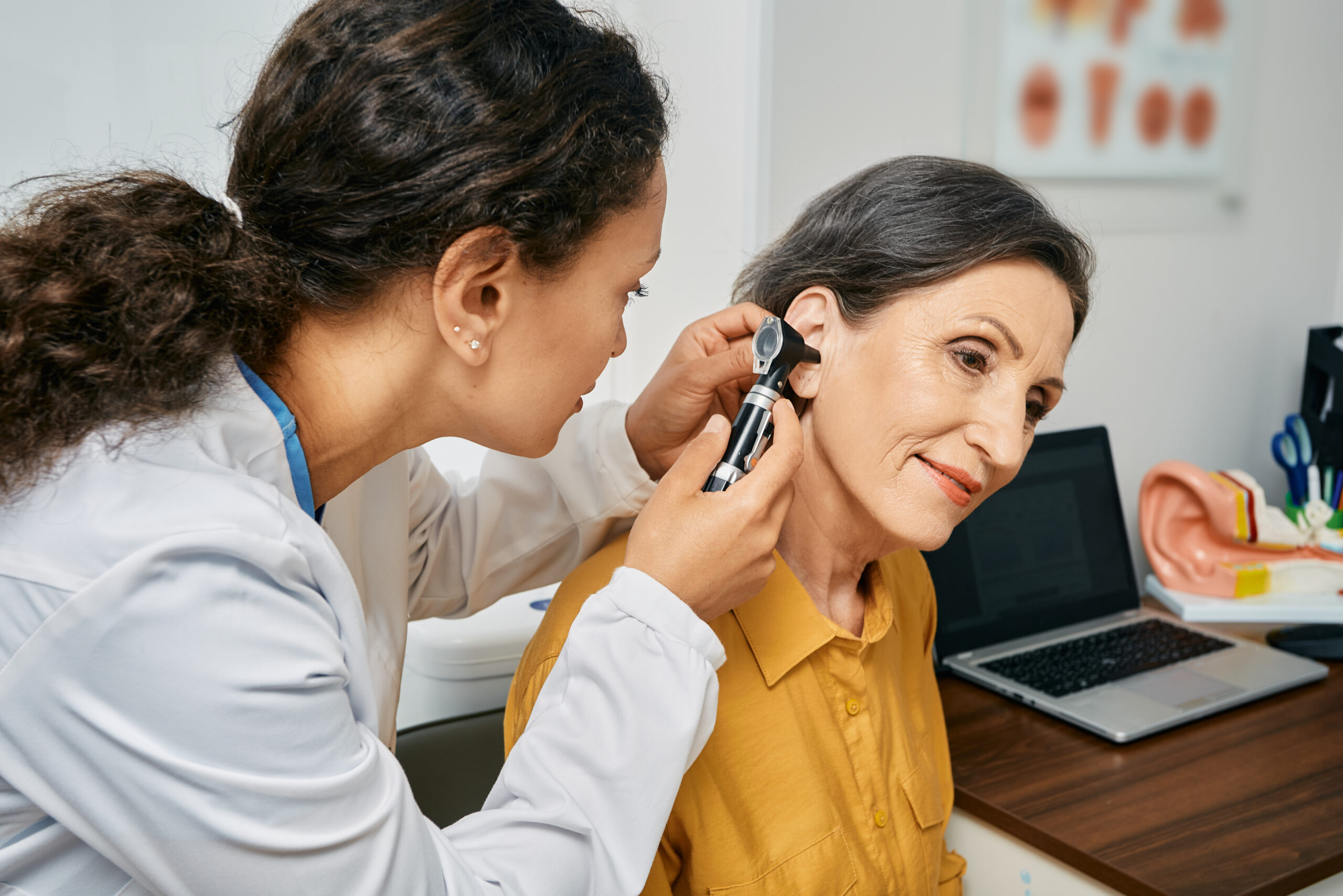 Doctor examines a female patient's ear
