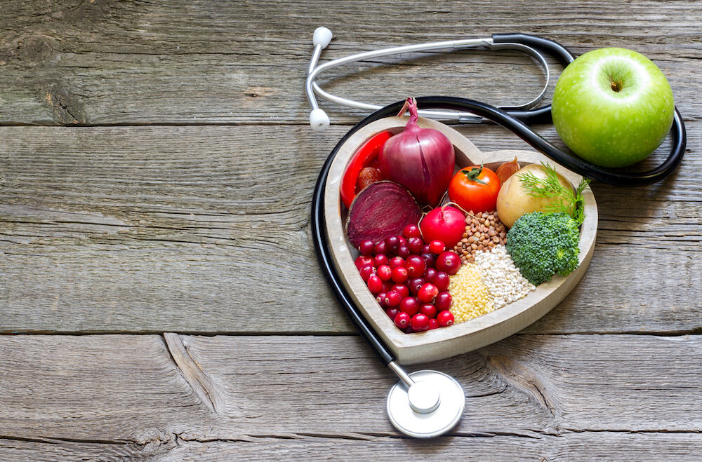 Healthy food in heart and cholesterol diet concept on vintage boards