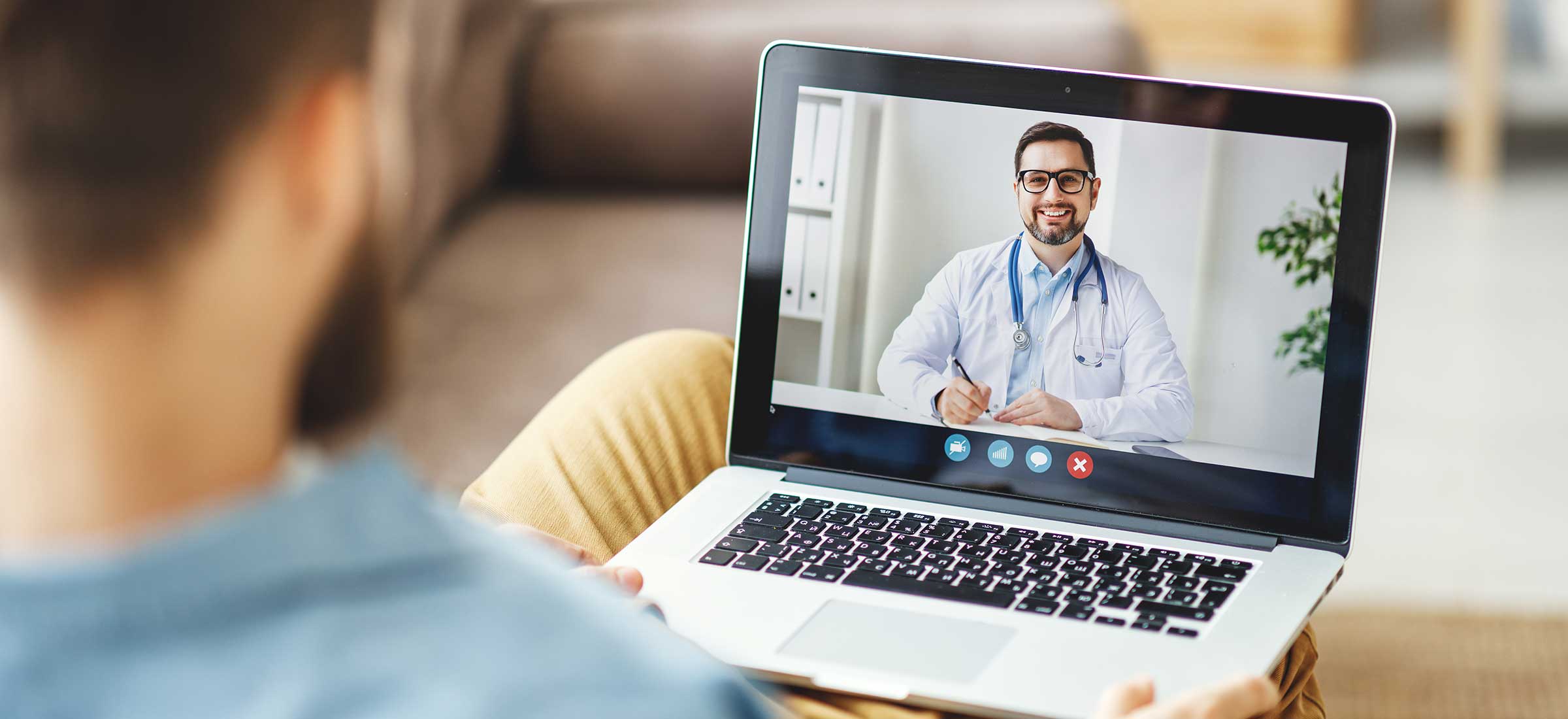 A young man conducts a video consultation with a doctor online sitting at home.