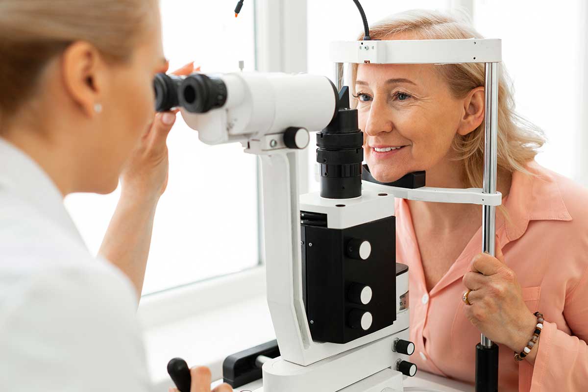 Pleasant short-haired woman with blue eyes having her eyes checked in binocular apparatus.