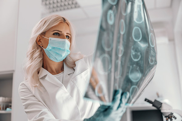 Dedicated doctor holding x-ray of the patient's brain and looking at it.