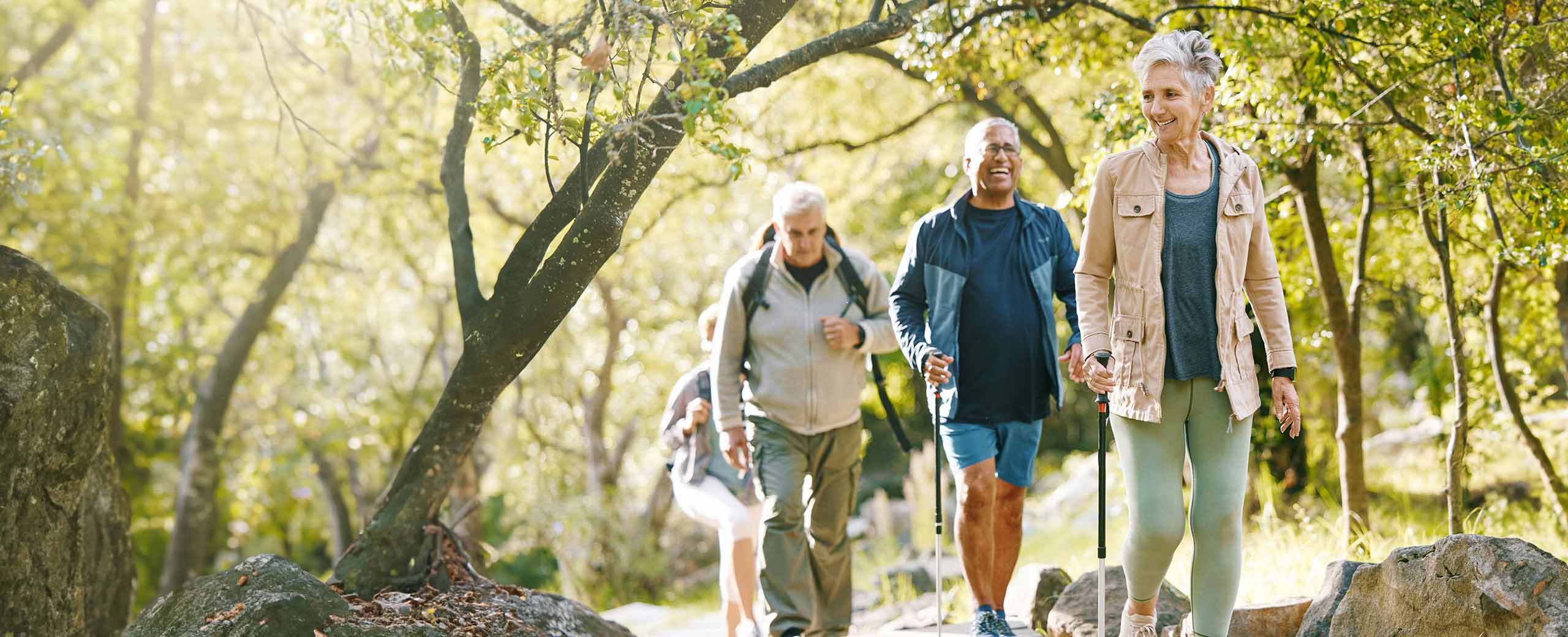 A group of happy older adults hiking on a trail at a park
