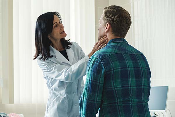 Physician examining patient's neck