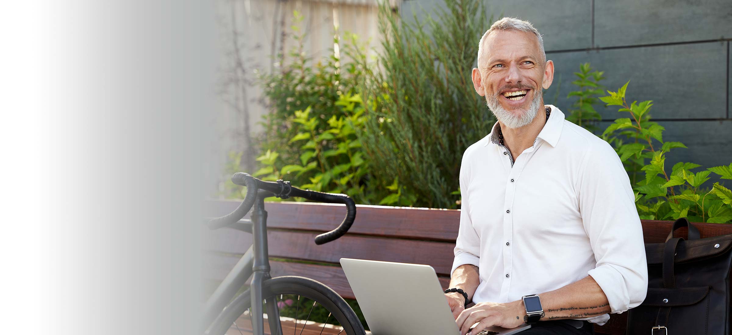 Person sitting on a bench with a laptop open