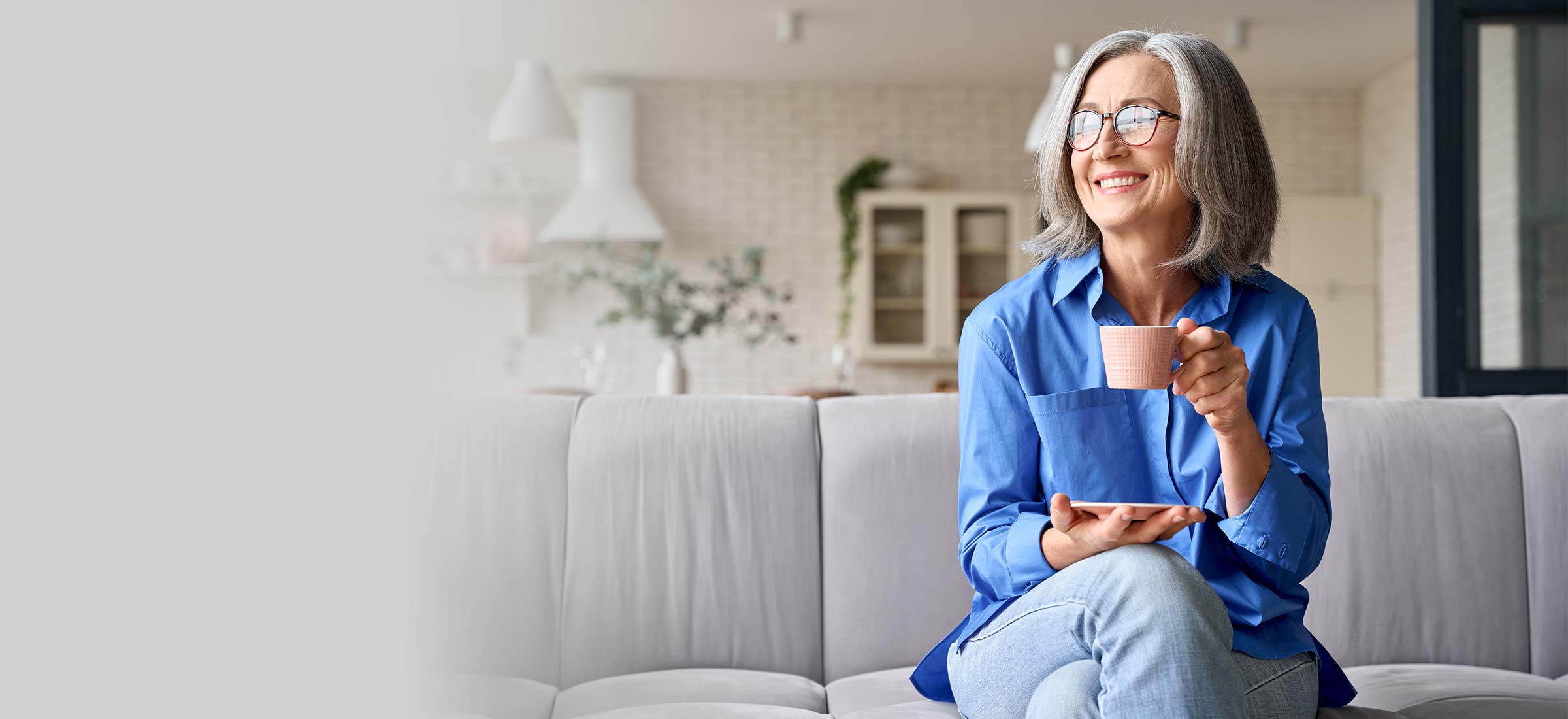 Person holding a cup sitting on a couch