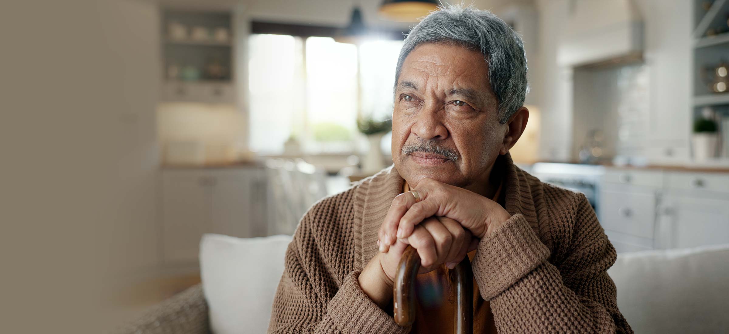 Man sitting with a cane