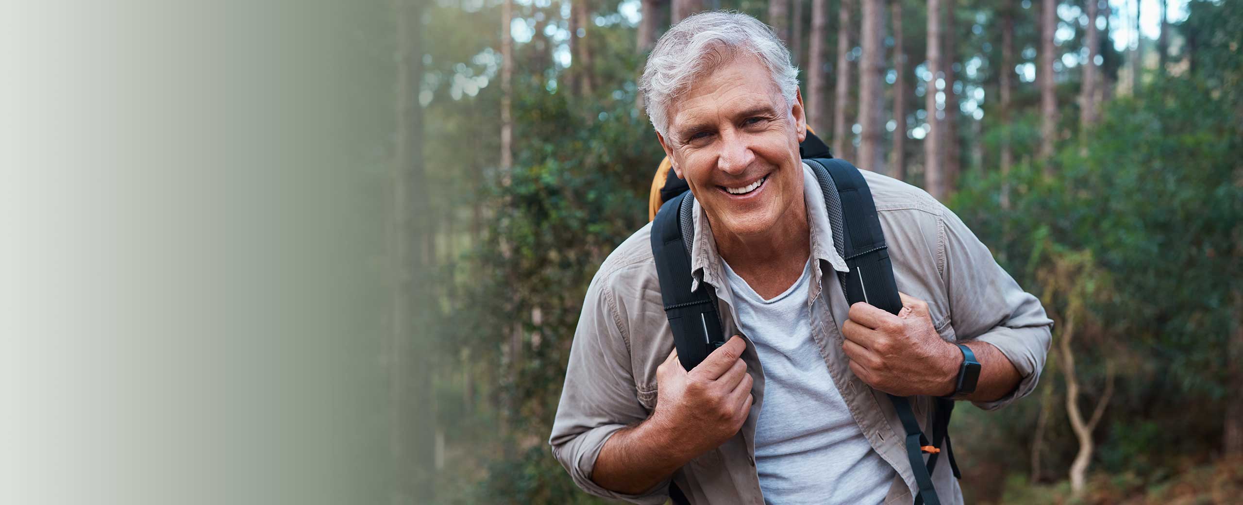 Happy senior man walking in forest