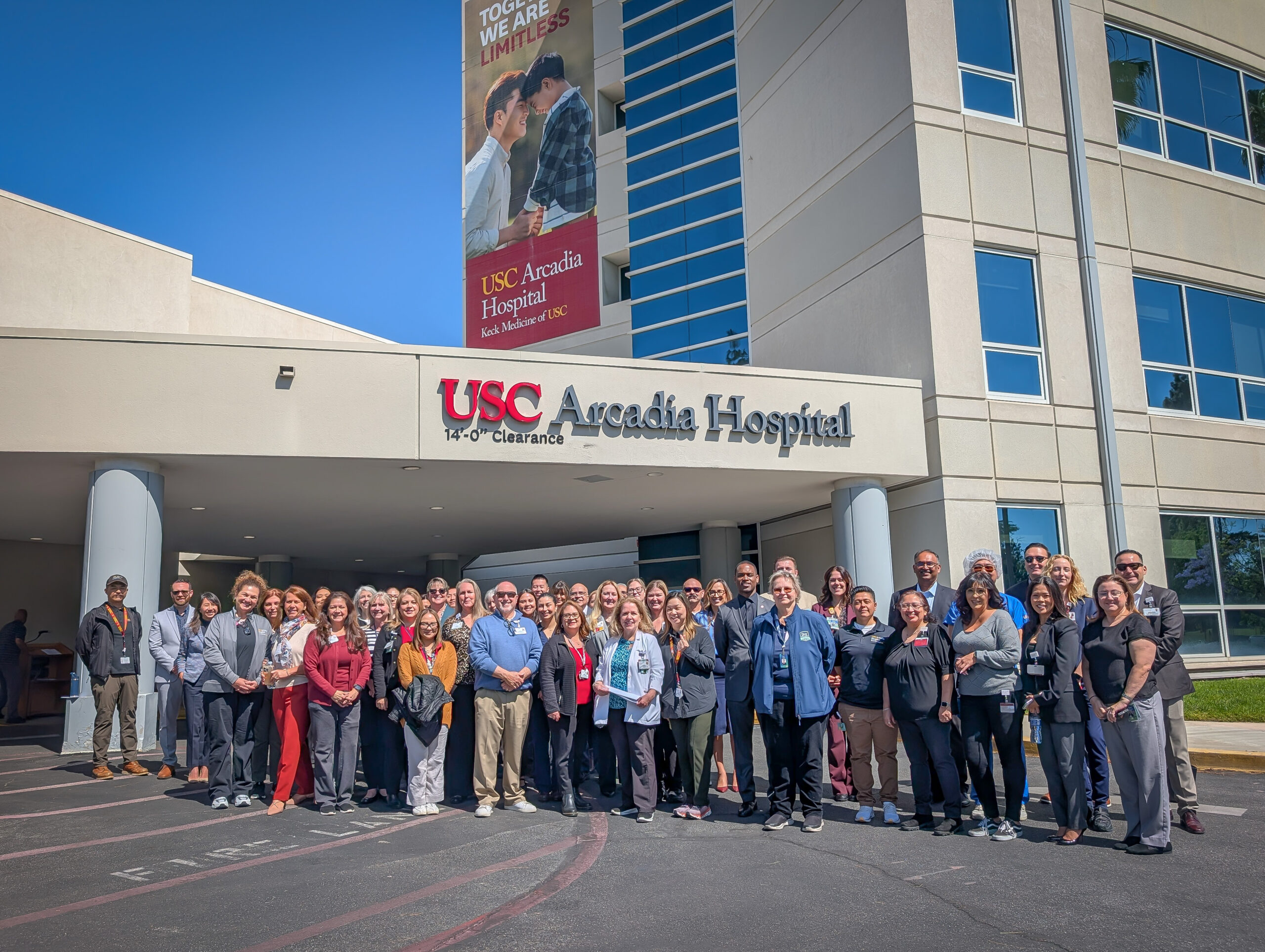 A crowd of people stand in front of USC Arcadia Hospital