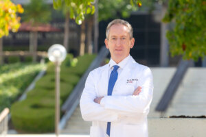 Dr. David Liebeskind stands outside in a white medical coat.
