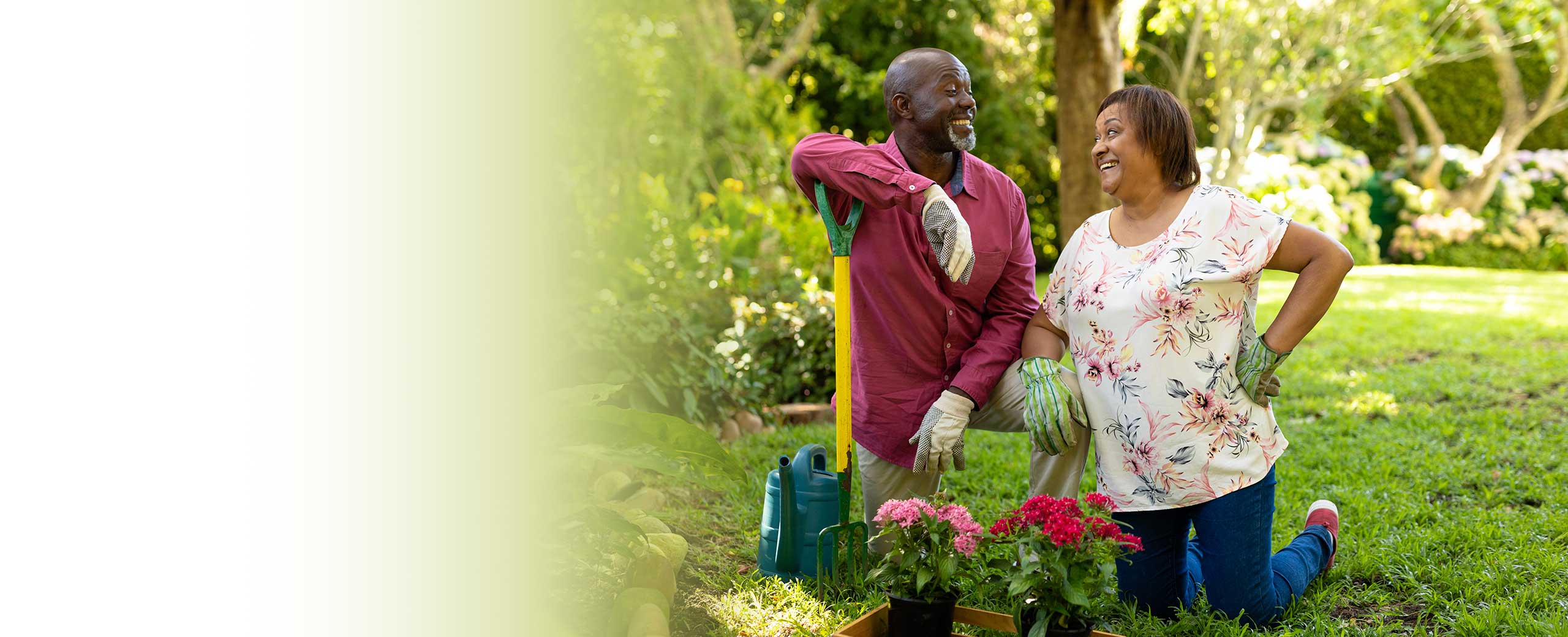 A couple stands in a garden and smiles.