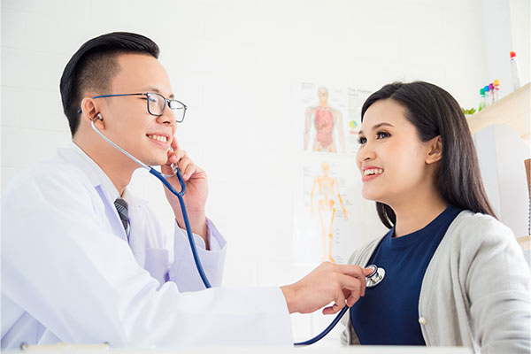 A doctor checks a woman to see if she's eligible for a loop recorder implantation.